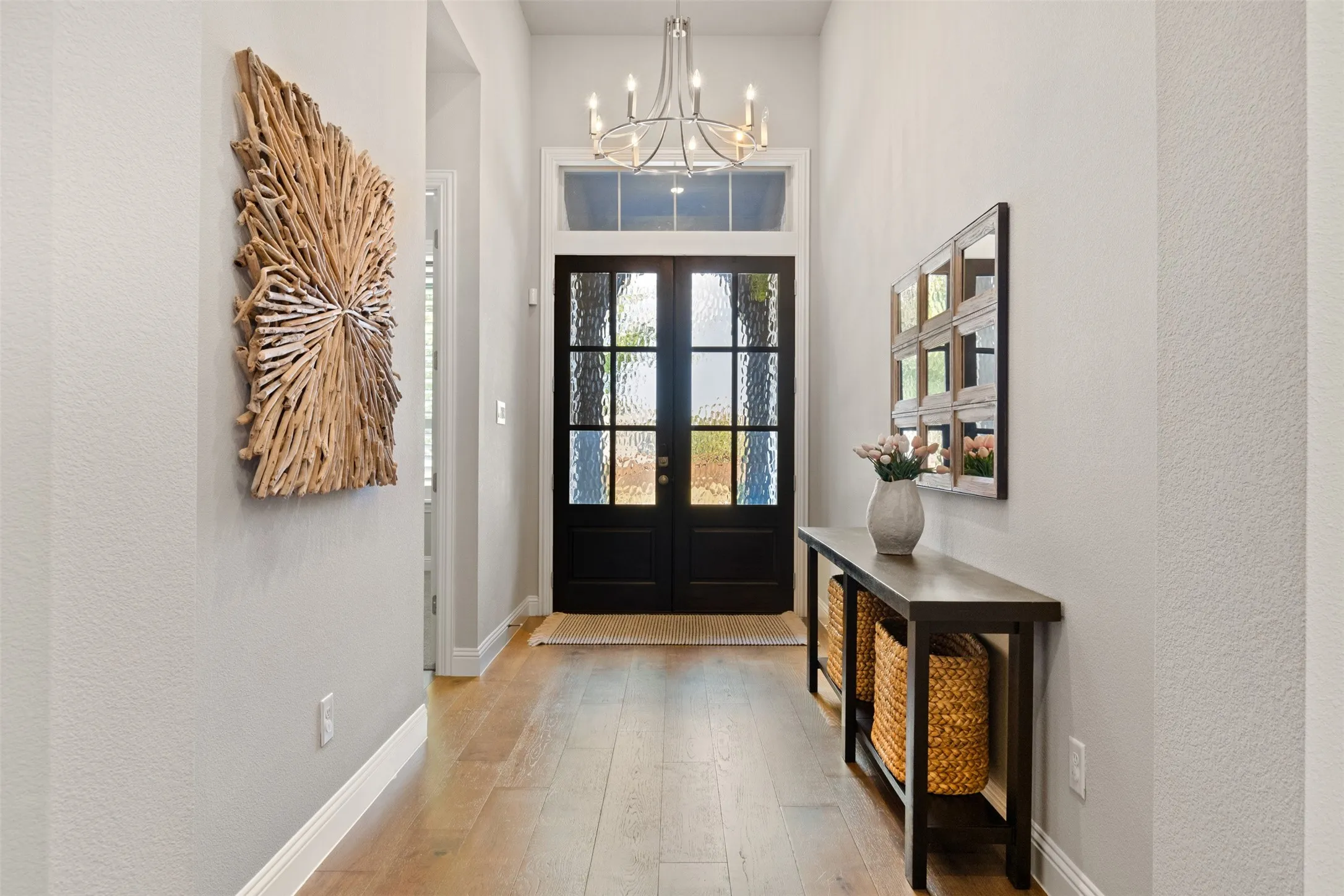 Entryway featuring a double door with textured glass, transom window, and wood-finish flooring