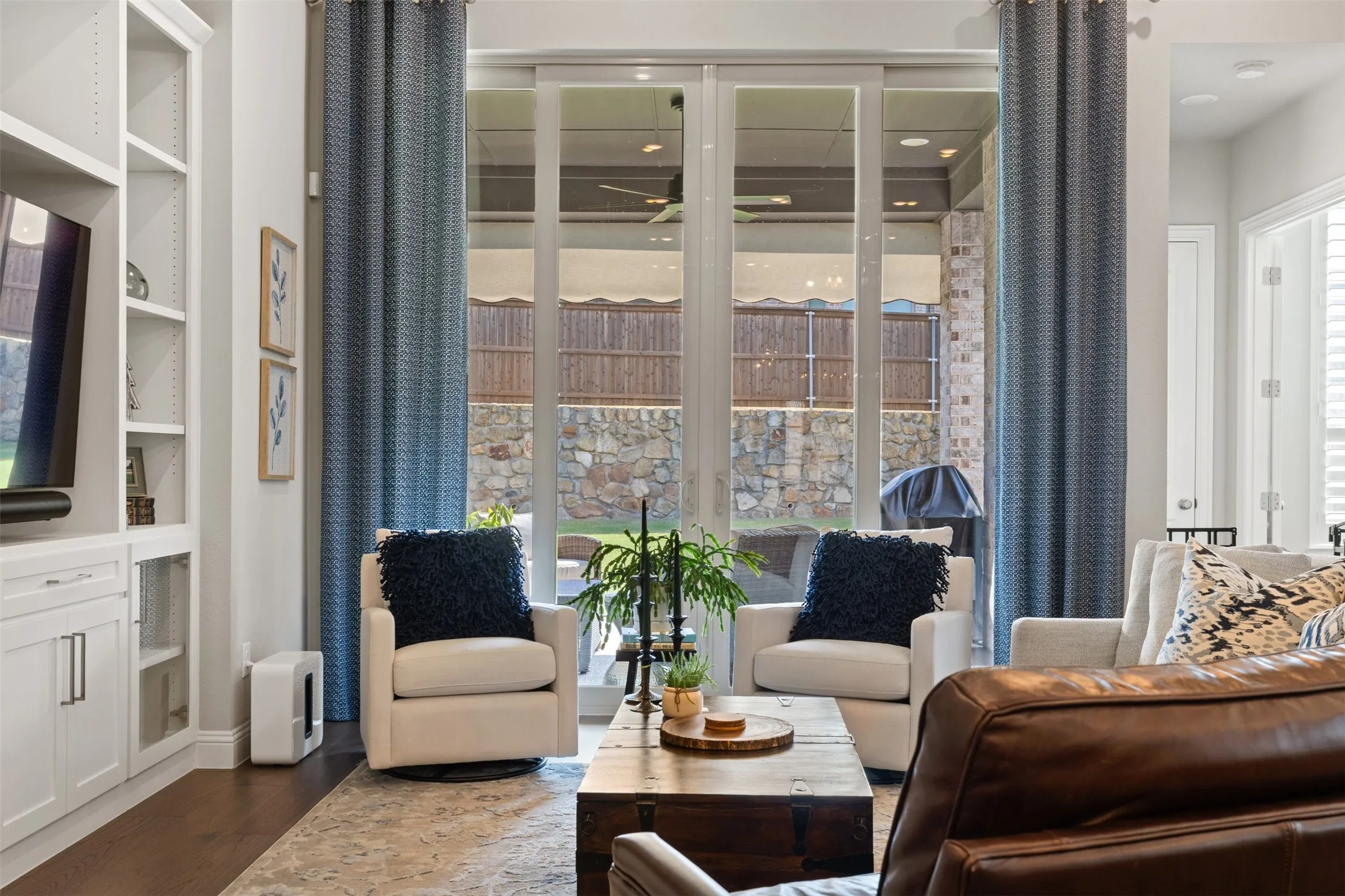 Living room with integrated built-in cabinetry, wood-finish flooring, recessed lighting, and large sliding glass doors