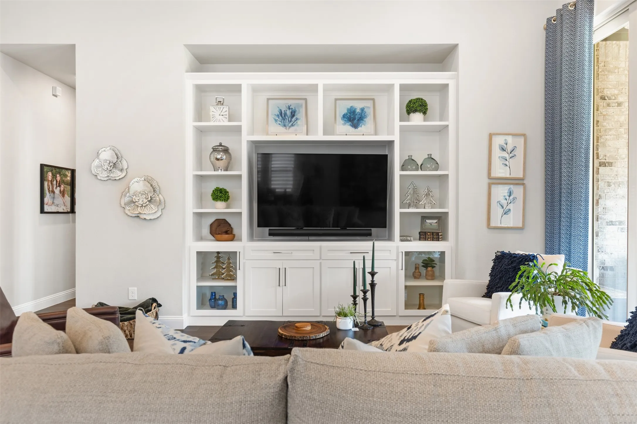 Living room with integrated built-in cabinetry, wood-finish flooring, recessed lighting, and large sliding glass doors