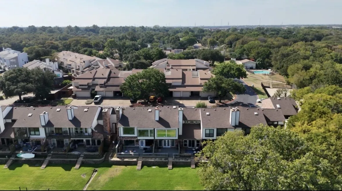 Terraced waterfront properties featuring individual patios, a private dock, and mature trees
