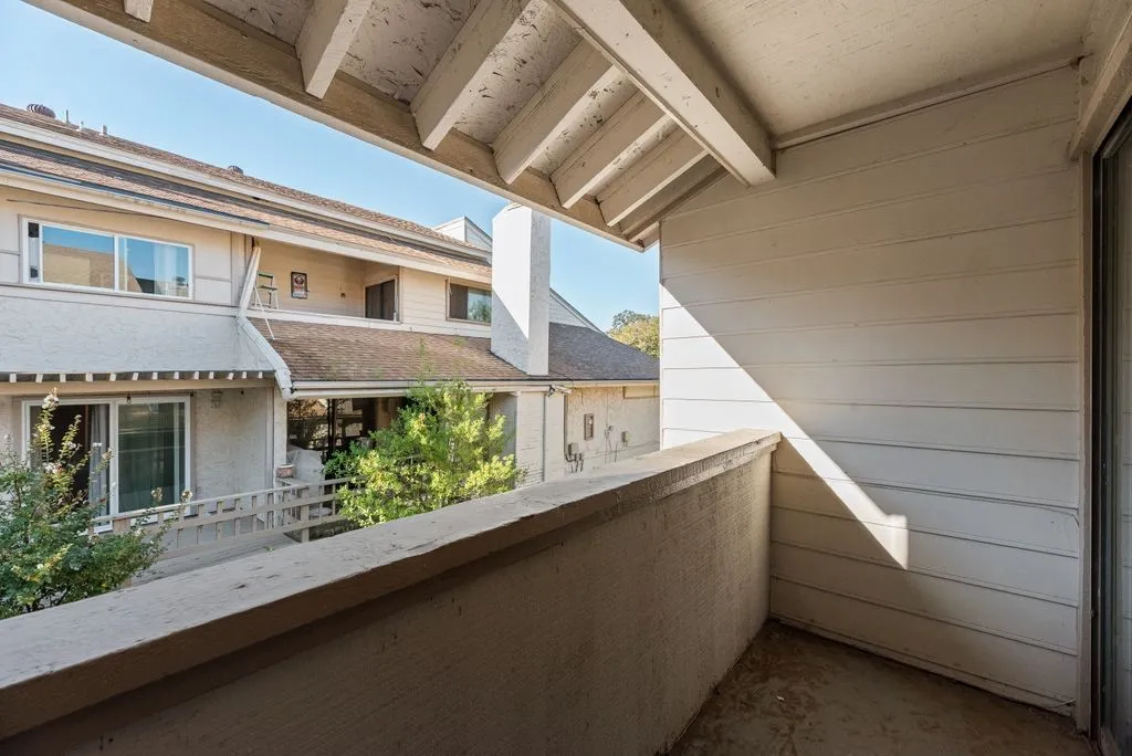 Private balcony with a concrete floor and a sliding glass door off of Primary Bedroom