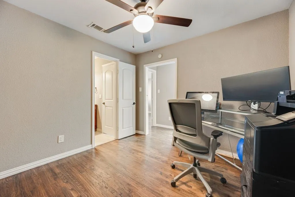 Bedroom 3- Wood-finish flooring, neutral wall tones, ceiling fan with integrated lighting, and white trim accents