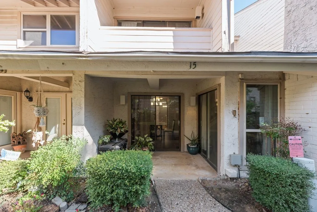 Entryway with a sliding glass door, overhead lighting, and surrounding mature landscaping