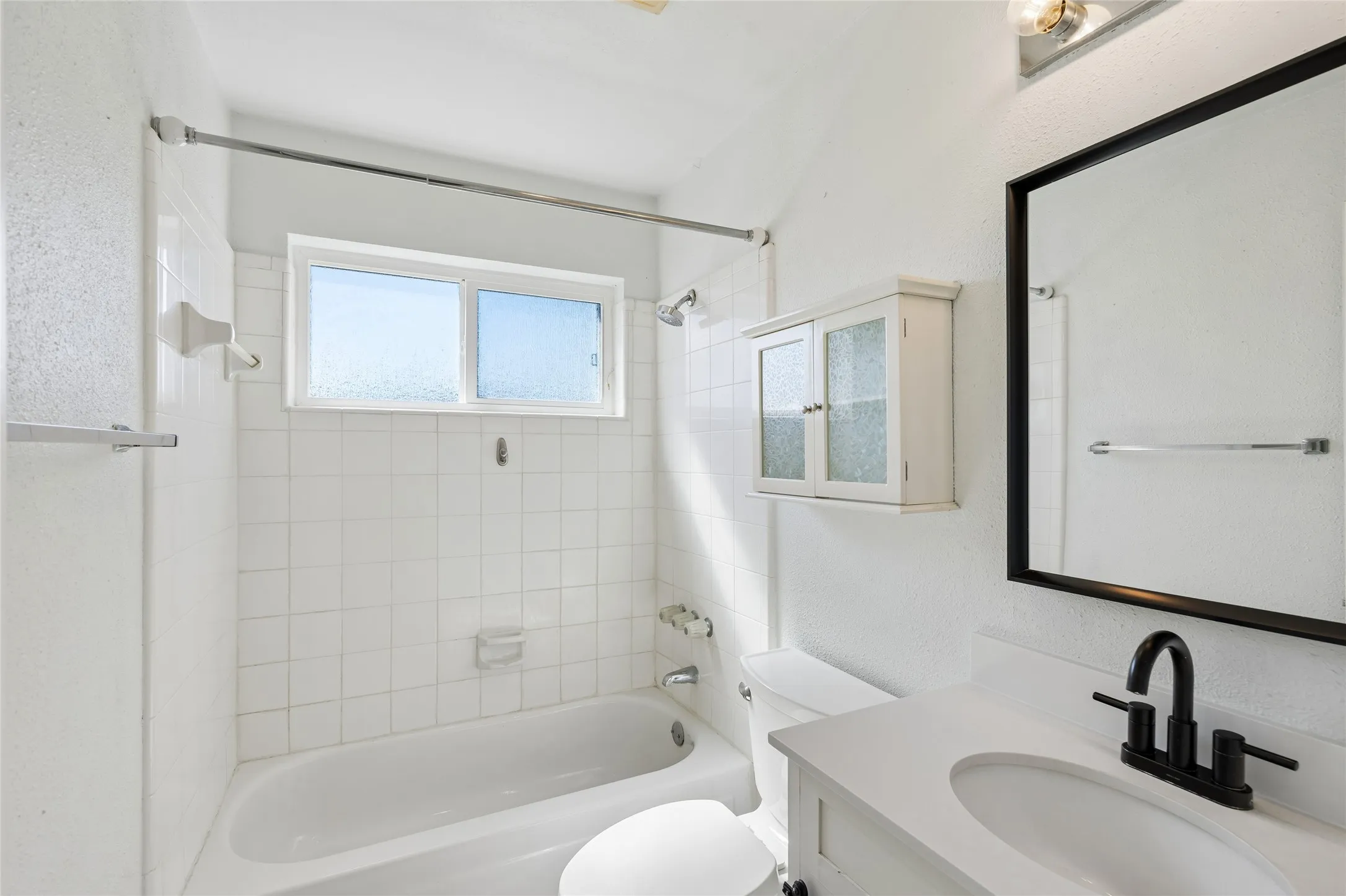 The full bath features a combination  tub/shower and updated barn-door vanity.