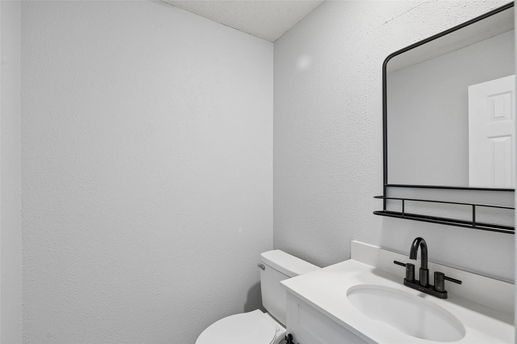 A half bath on the first floor with updated barn-door vanity offers convenient access to guests.