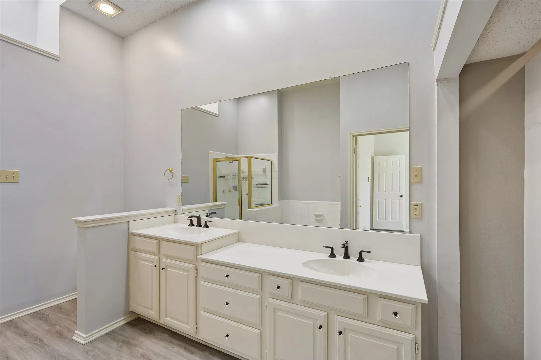 The bright primary bath features dual sinks, built-in  cabinets and a skylight.