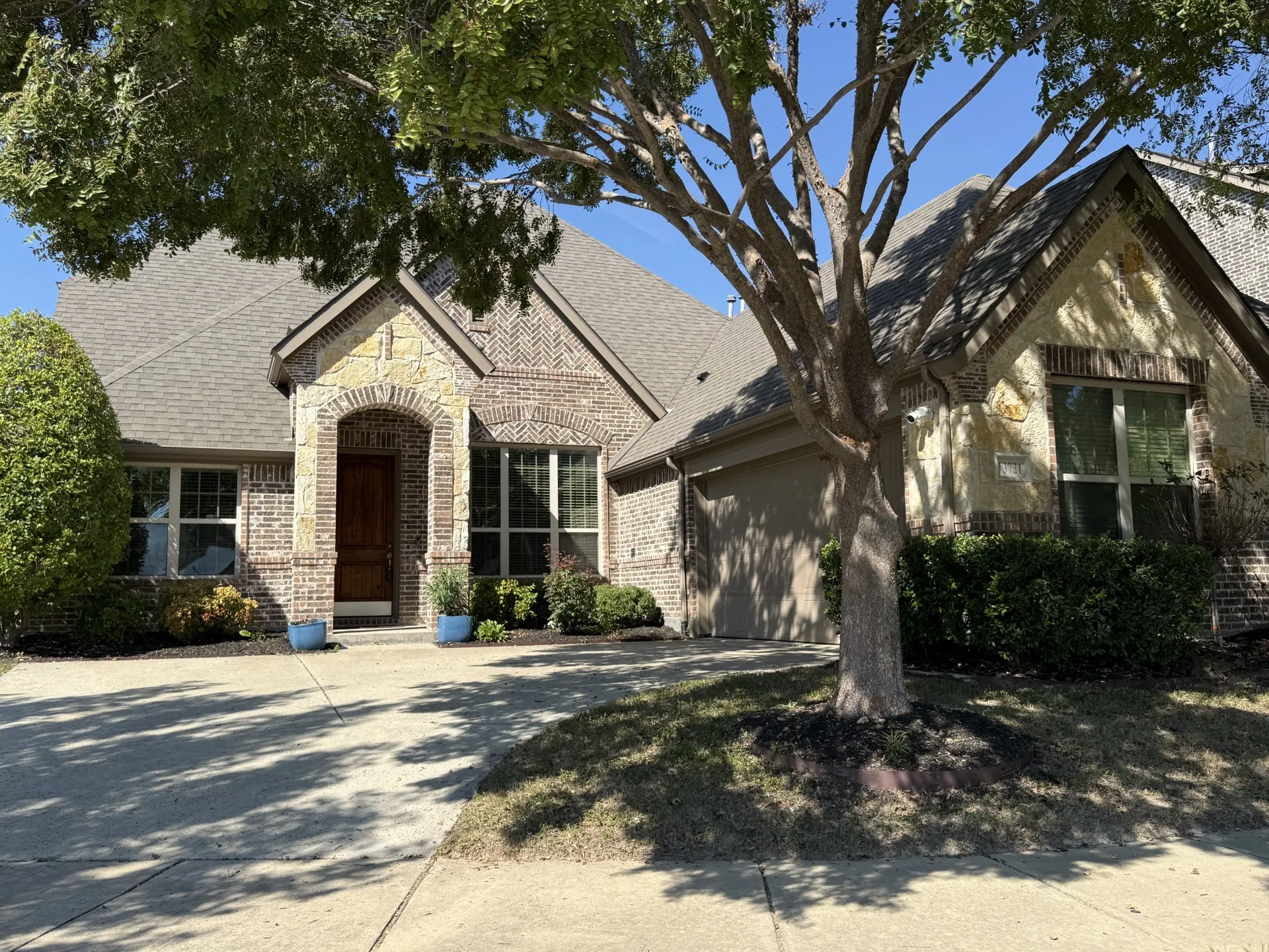 Brick exterior with stone accents, arched entryway, and an attached garage