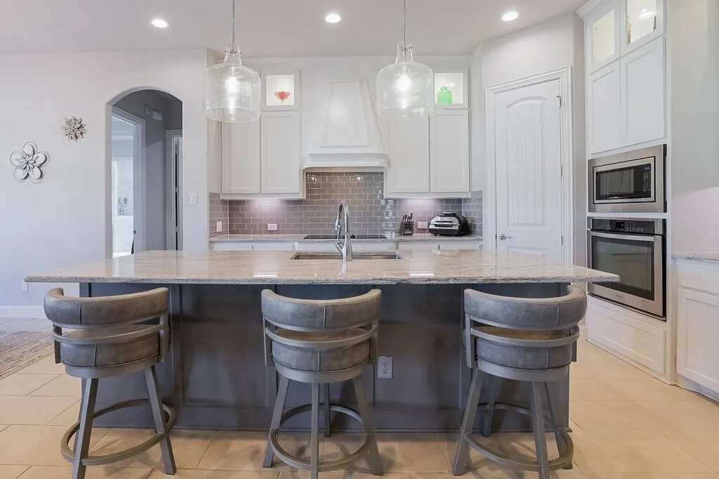 Kitchen featuring a large island, stainless steel built-in oven and microwave, recessed lighting, and tile flooring