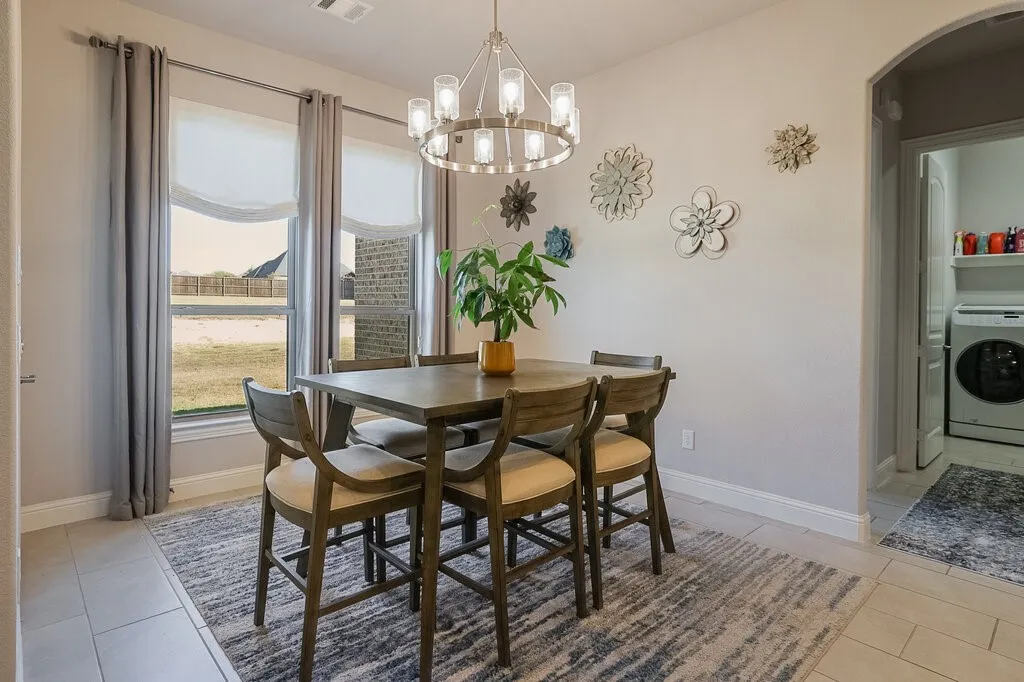 Dining area with tile flooring, a contemporary chandelier, and large windows
