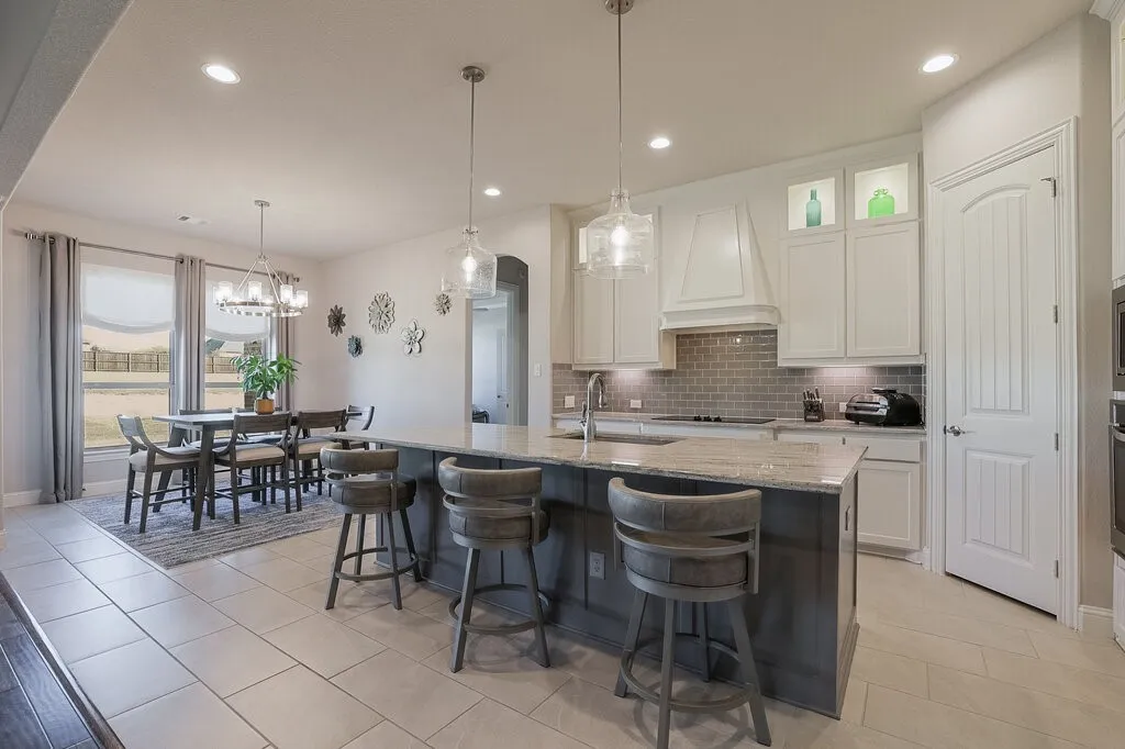 Kitchen featuring a central island, recessed lighting, pendant lighting, light-toned cabinetry, and a subway tile backsplash