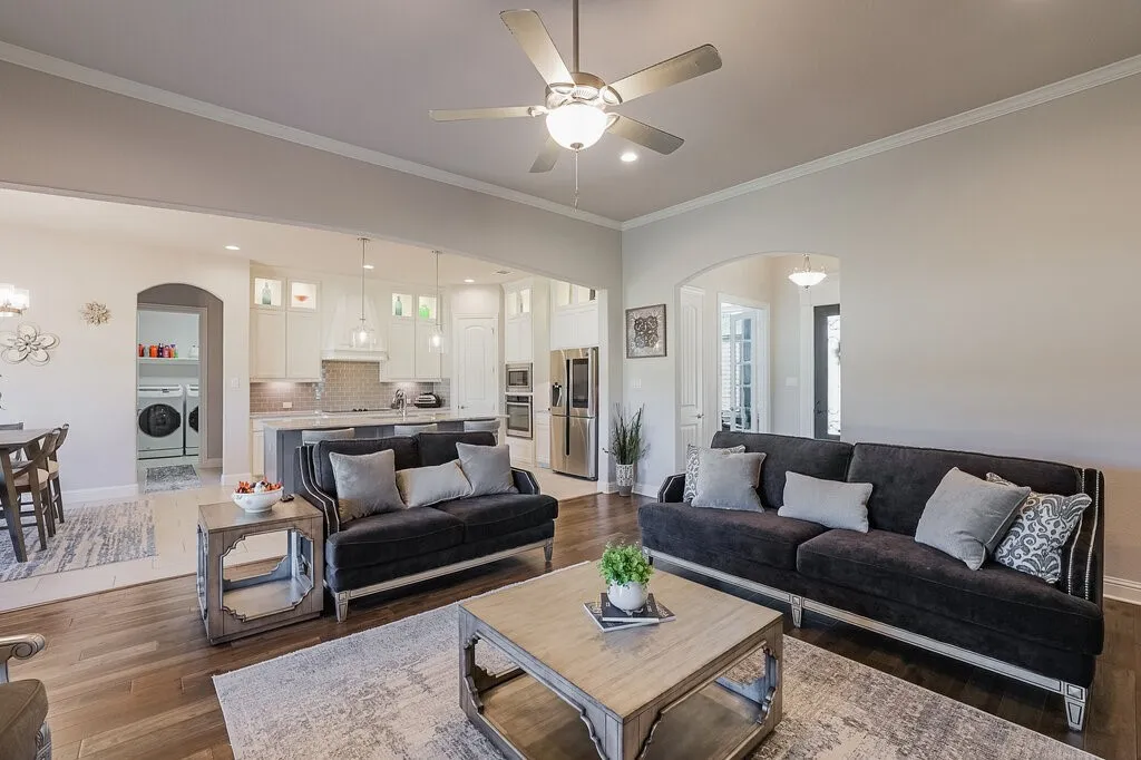 Open-concept living area featuring wood-finish flooring, recessed lighting, and crown molding