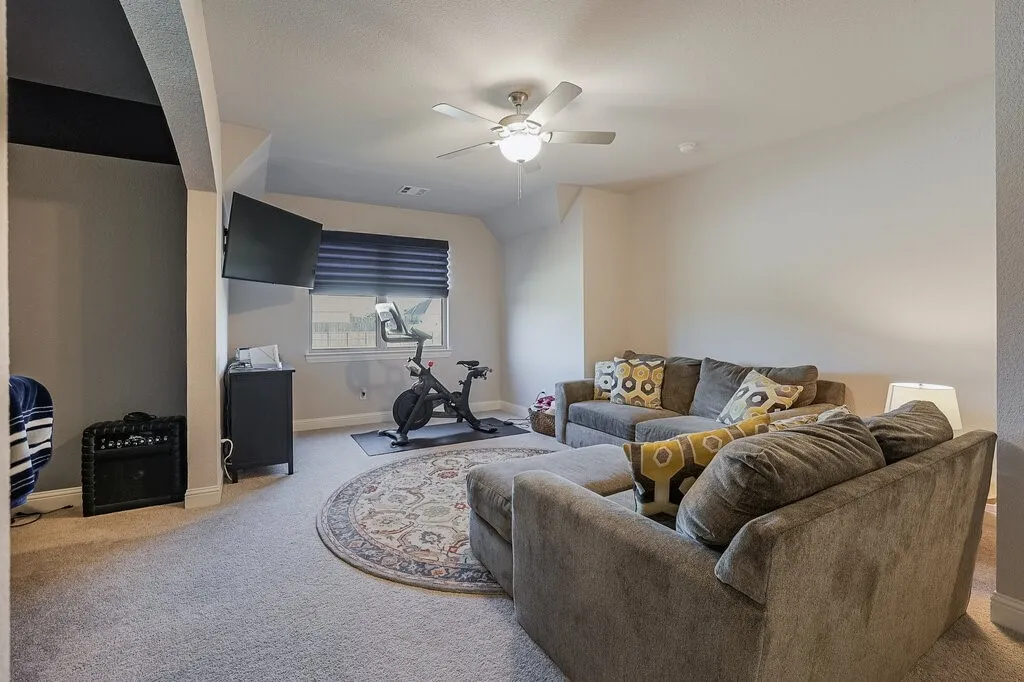 Recessed window with horizontal blinds, built-in ceiling fan, and carpeted flooring