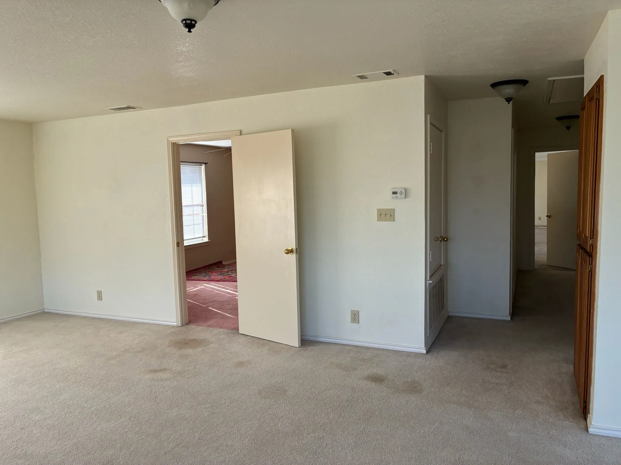 Unfurnished bedroom with light carpet and a textured ceiling