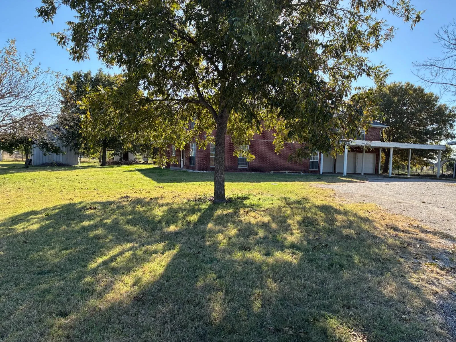 View of grassy yard featuring an attached carport