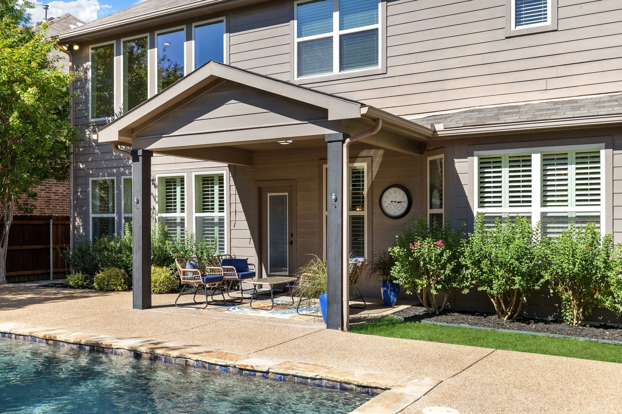 Covered patio with a pitched roof, outdoor ceiling fan, and recessed lighting