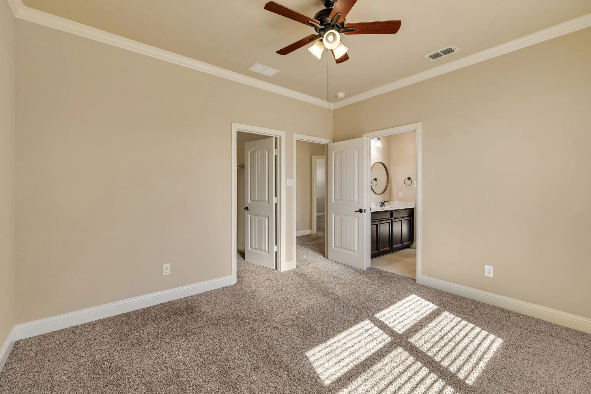 Carpeted room with crown molding, ceiling fan, and white doors
