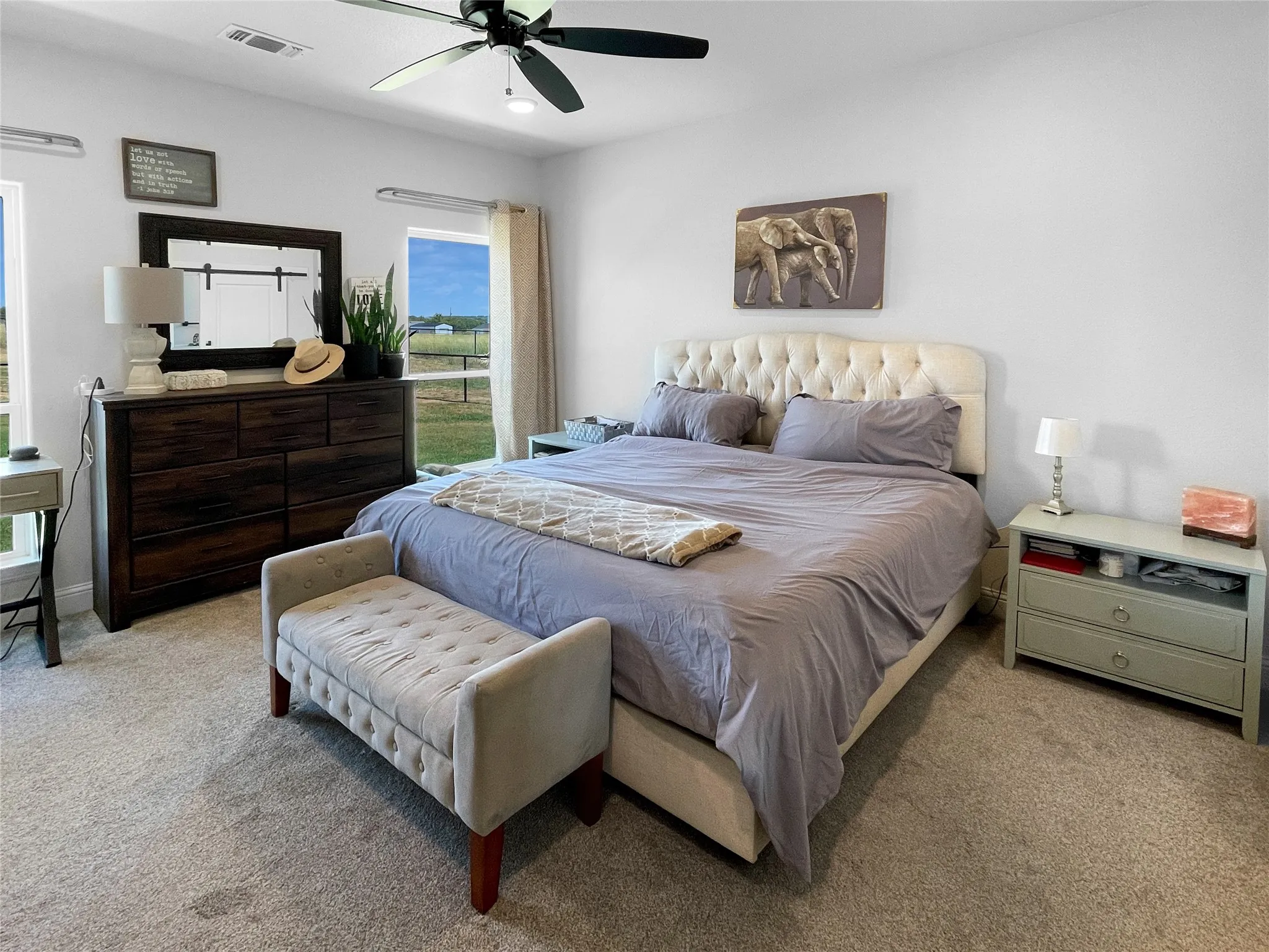 Carpeted flooring, ceiling fan, and large windows with extensive outdoor scenery