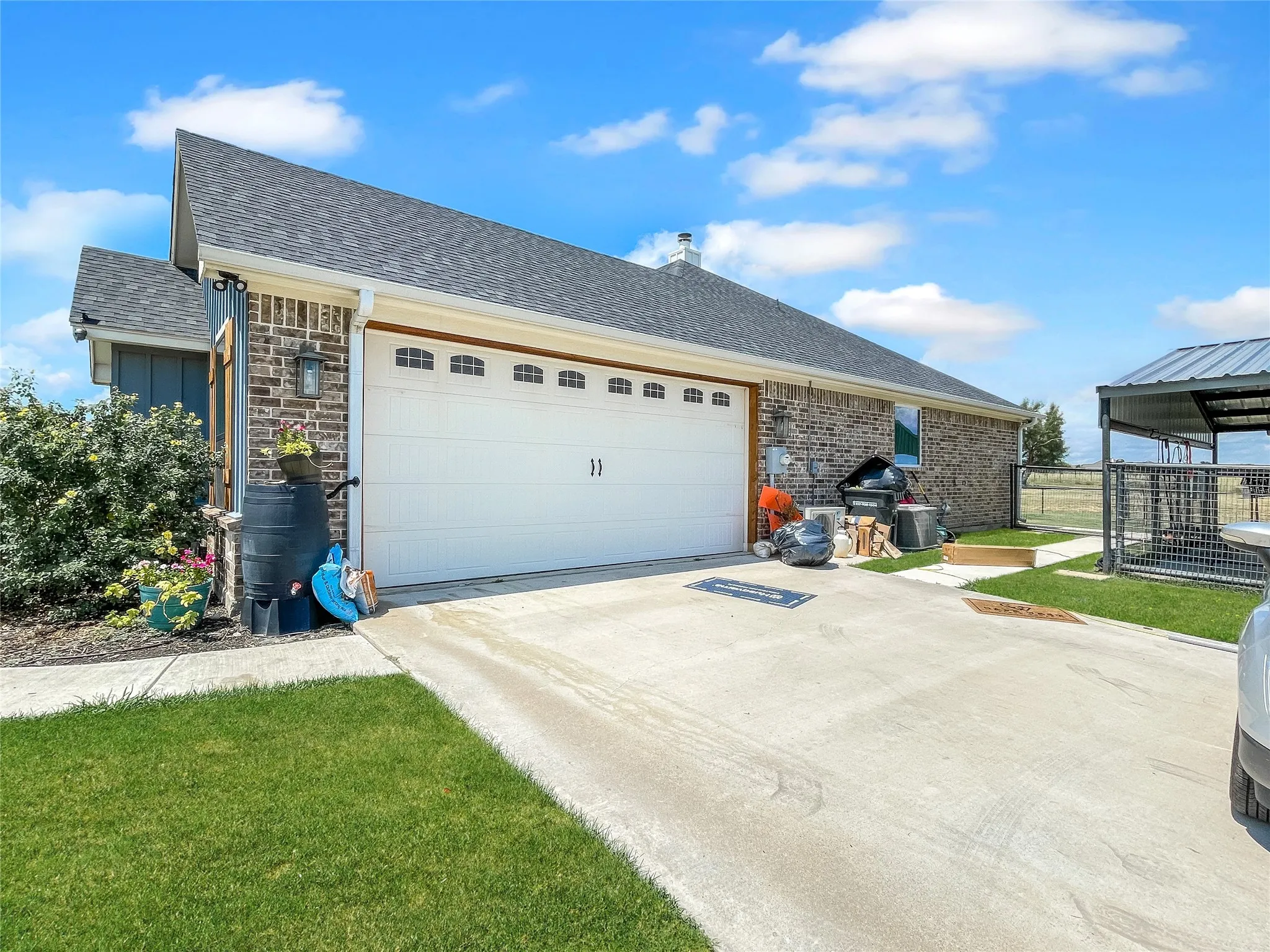 Attached garage with a concrete driveway and an exterior light fixture