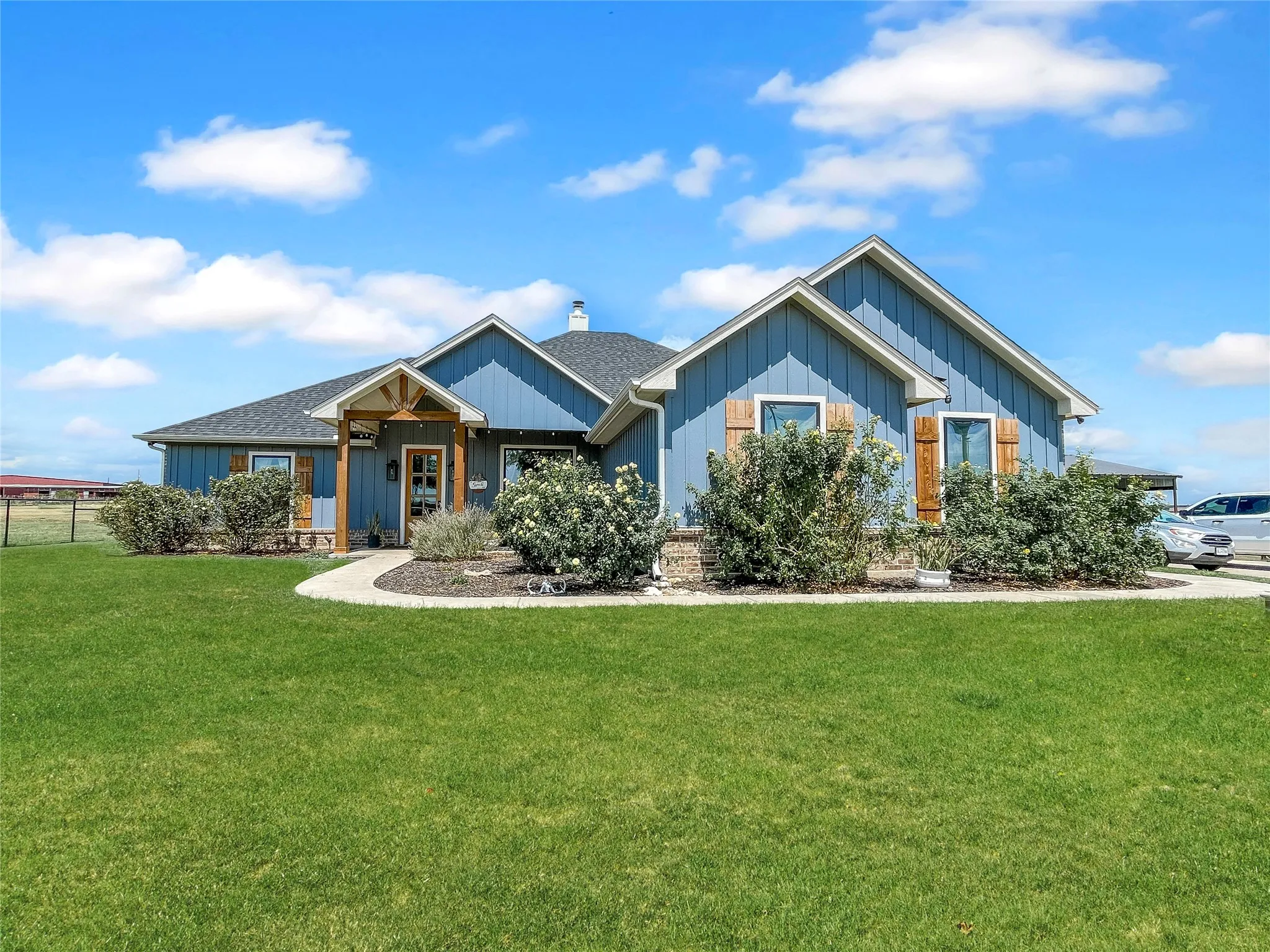 Blue siding exterior with gabled roof lines and wood-finish shutters
