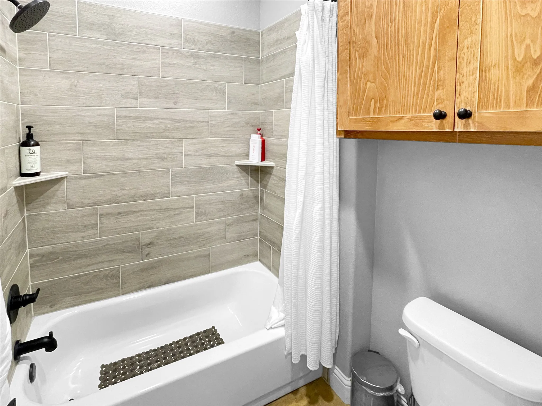 Bathtub and shower combination with wood-look tile surround