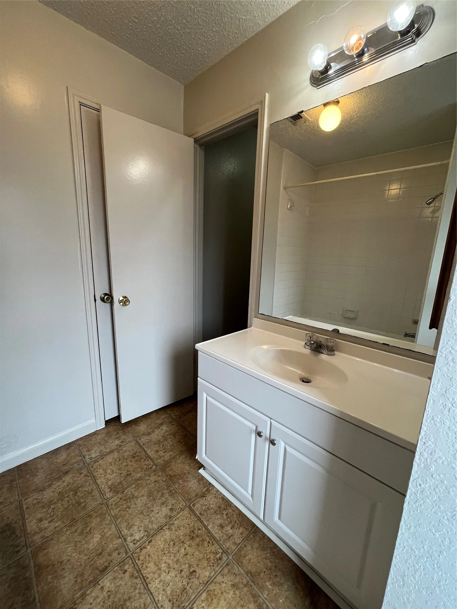 Bathroom featuring vanity, a textured ceiling, and tile patterned flooring