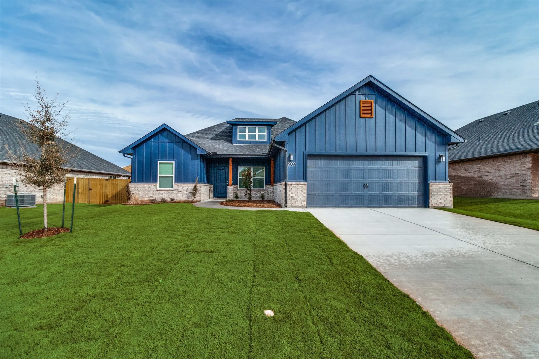 Single-story residence featuring blue vertical siding and stone accents