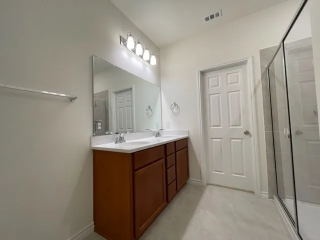 Dual vanity with brown cabinetry and white countertops