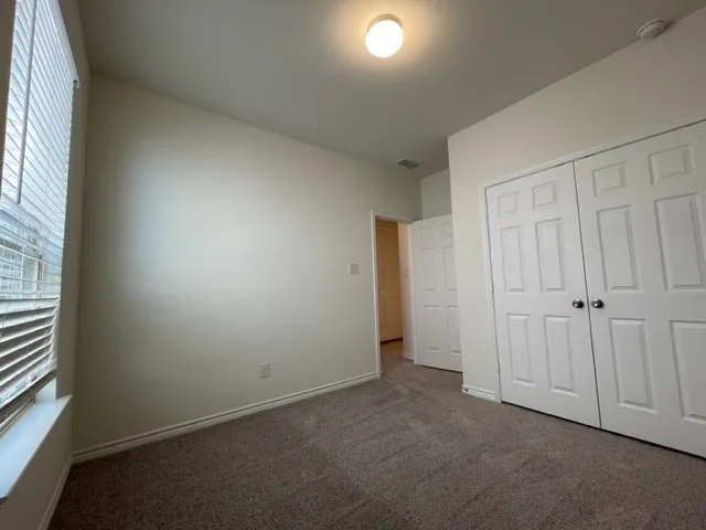 Carpeted flooring, window with blinds, bi-fold closet doors, recessed lighting, and neutral wall paint