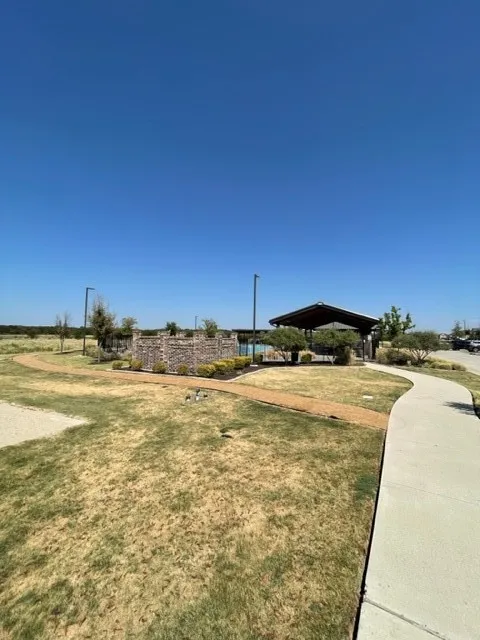 Community amenities featuring a covered pavilion, pool area, stone wall accents, and concrete pathways