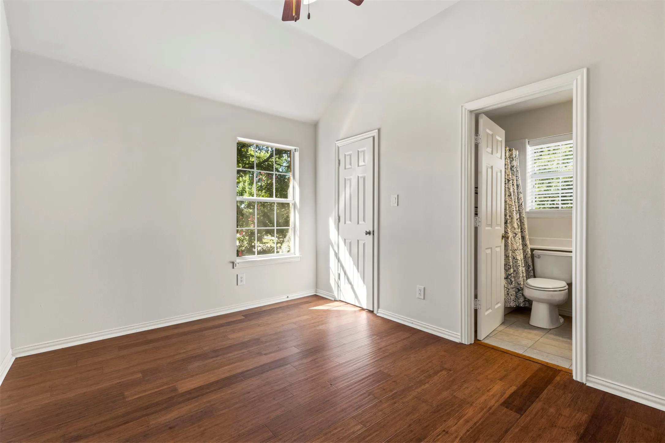 Wood-finish flooring, vaulted ceiling, and a ceiling fan