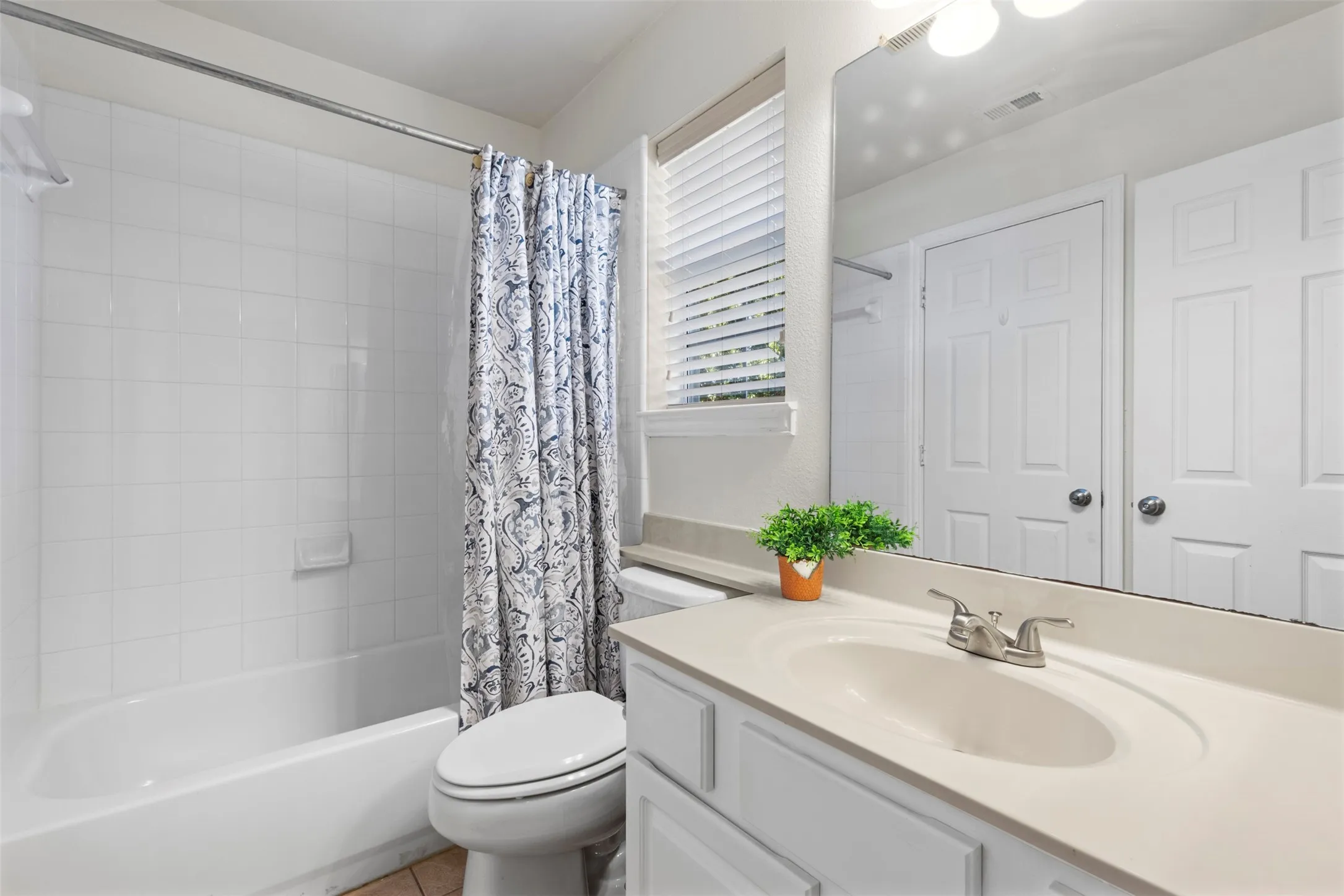White paneled vanity with an integrated sink and brushed nickel faucet