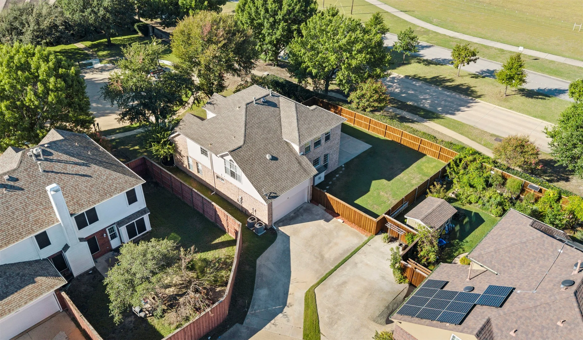 Two-story residence with a gabled roof, private fenced yard, and an attached two-car garage