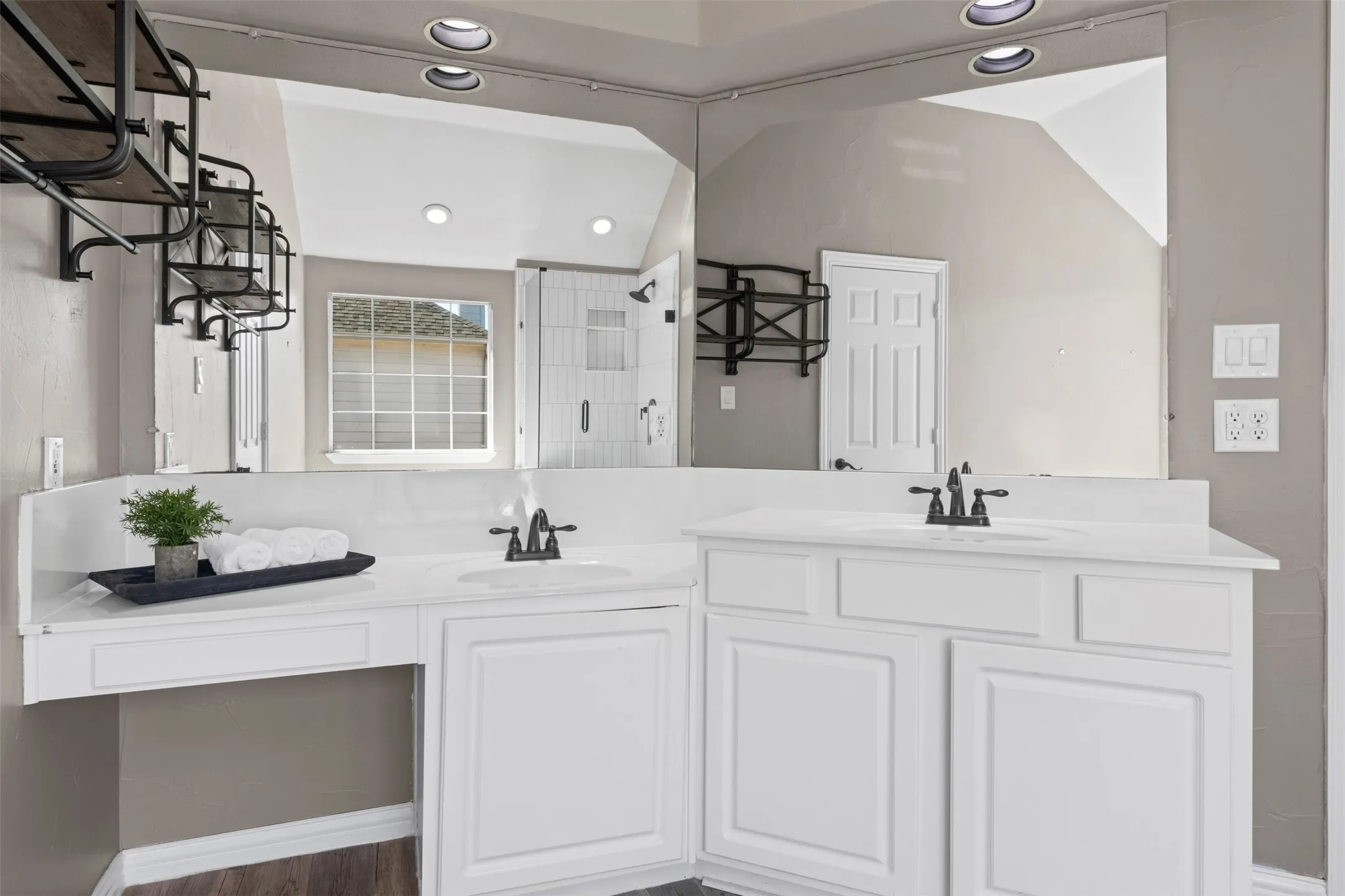 Dual vanity with white cabinetry, integrated sinks, black finish faucets, and a full-width mirror