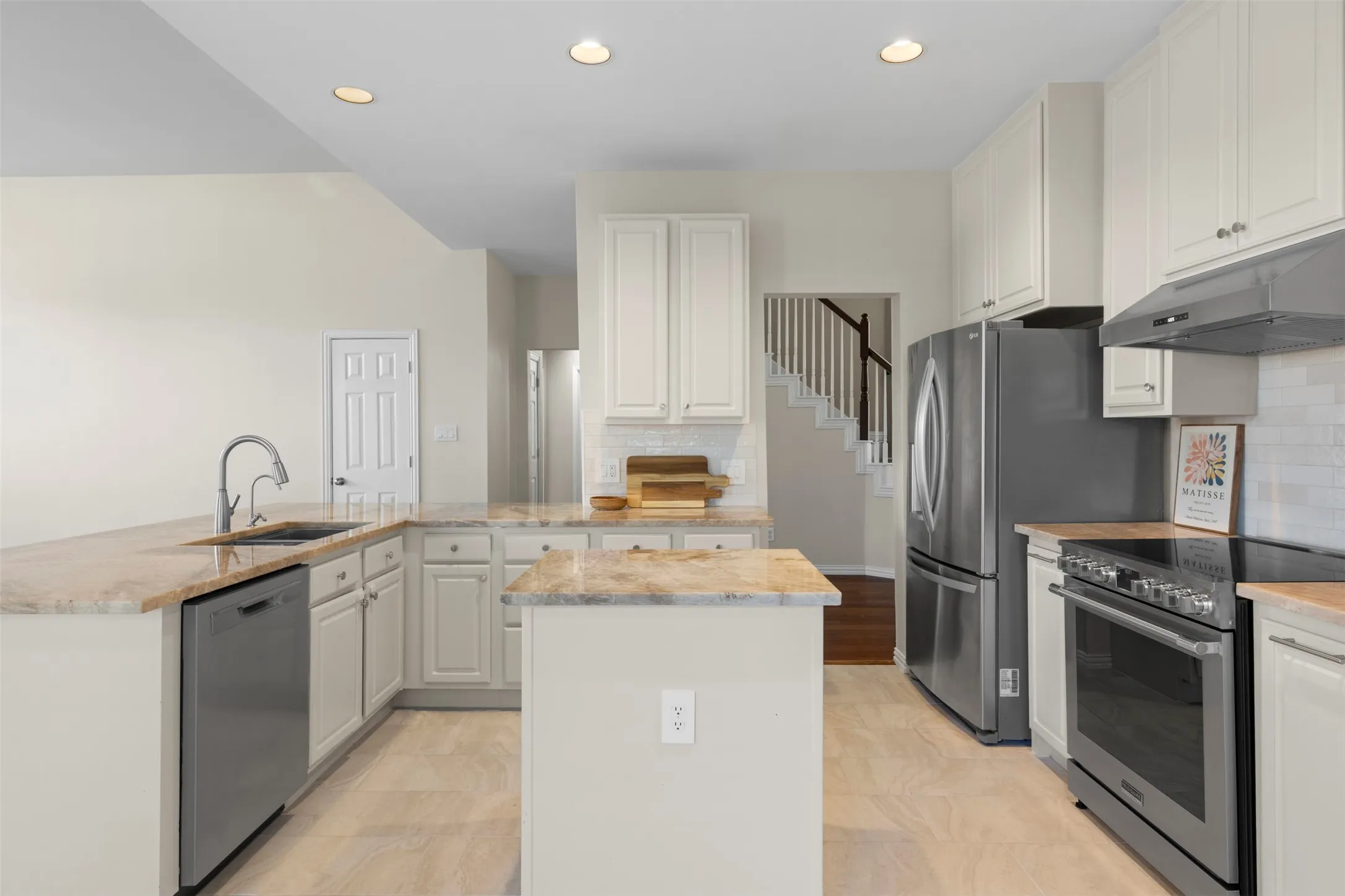 Kitchen featuring light-toned cabinetry, light-toned countertops, tile flooring, stainless steel appliances, and recessed lighting