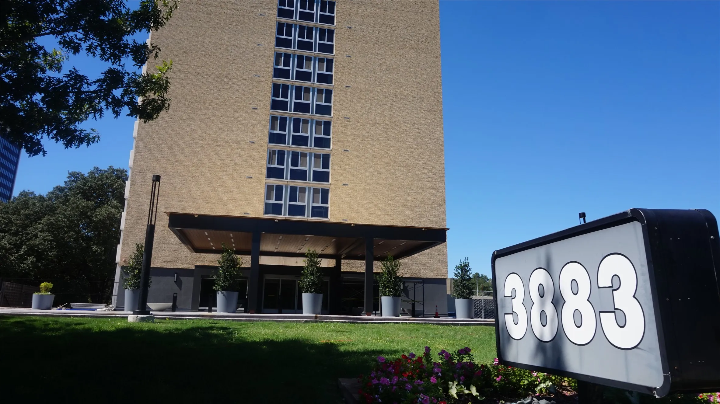 Brick-clad high-rise featuring multiple windows and a covered entrance