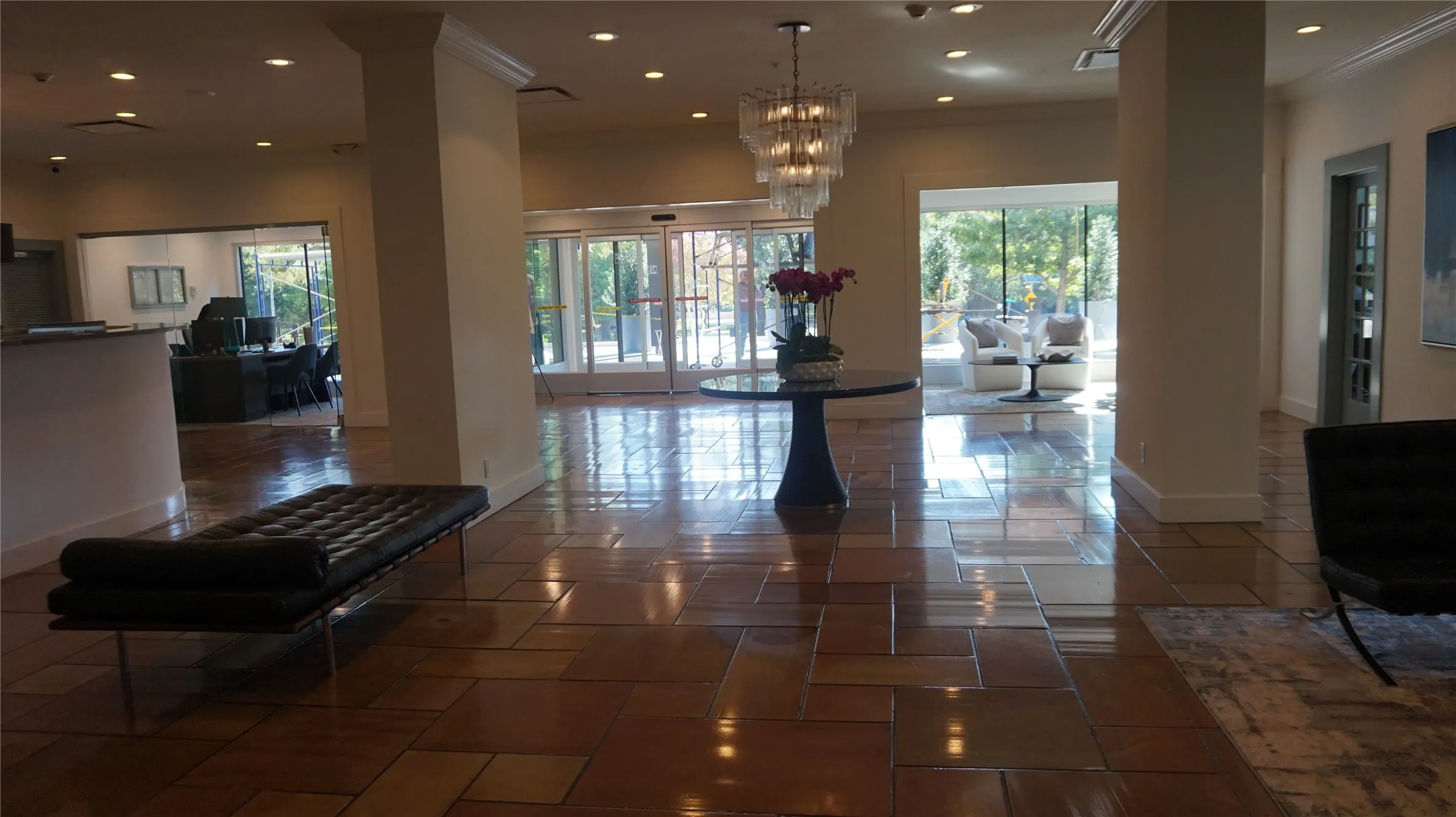 Spacious common area featuring large format floor tiles, recessed lighting, and a decorative chandelier
