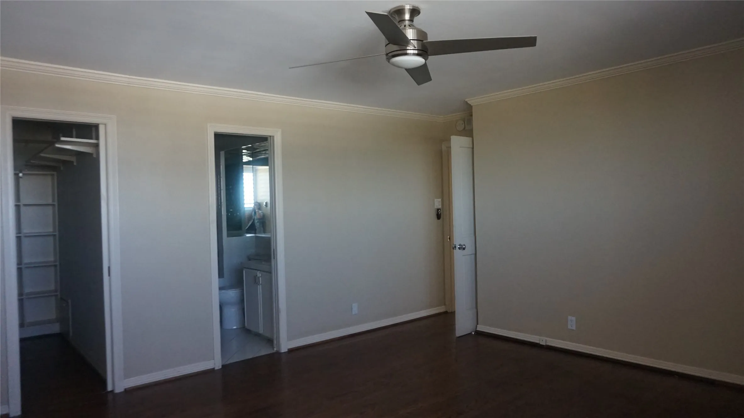 Wood-finish flooring, crown molding, and a modern ceiling fan with lighting