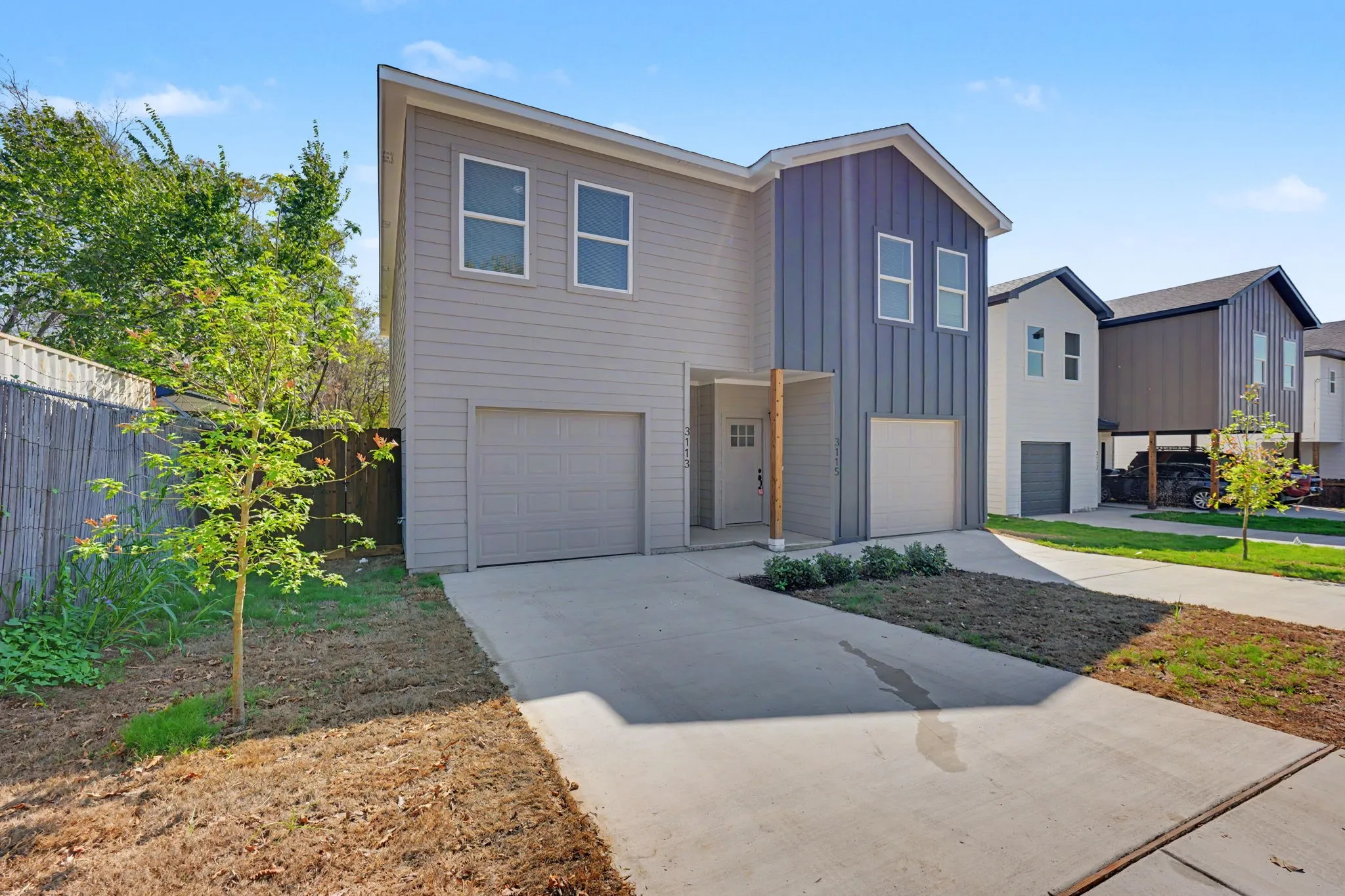 Contemporary exterior with a mix of vertical and horizontal siding, multiple windows, and a covered entry