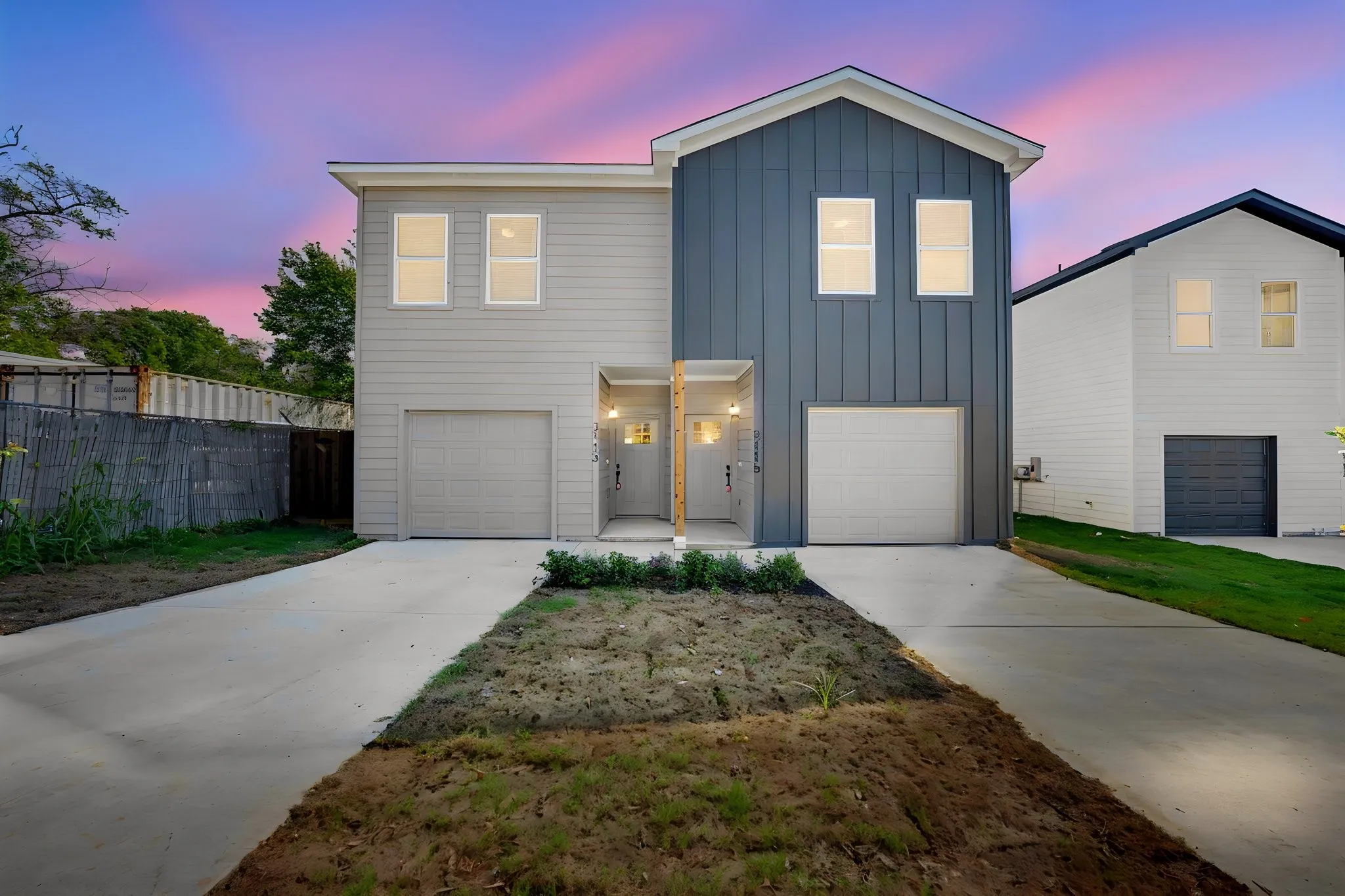 Contemporary exterior with vertical and horizontal siding, individual garages, and concrete driveways