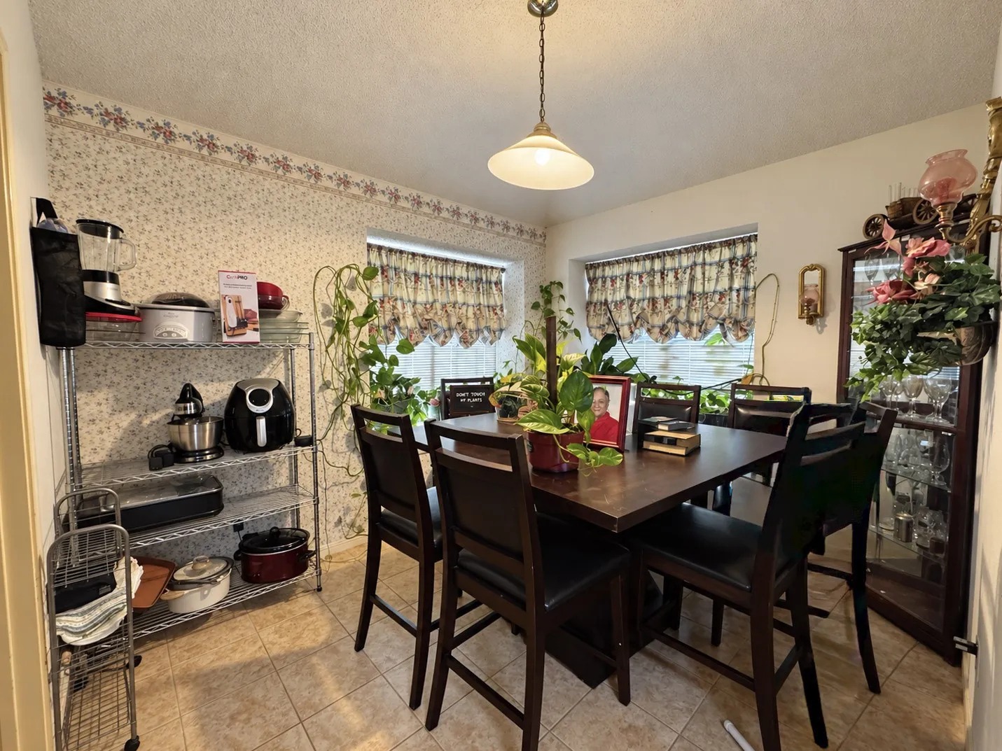 Dining space featuring a wood-finish table, recessed windows, tile flooring, and a ceiling-mounted light fixture