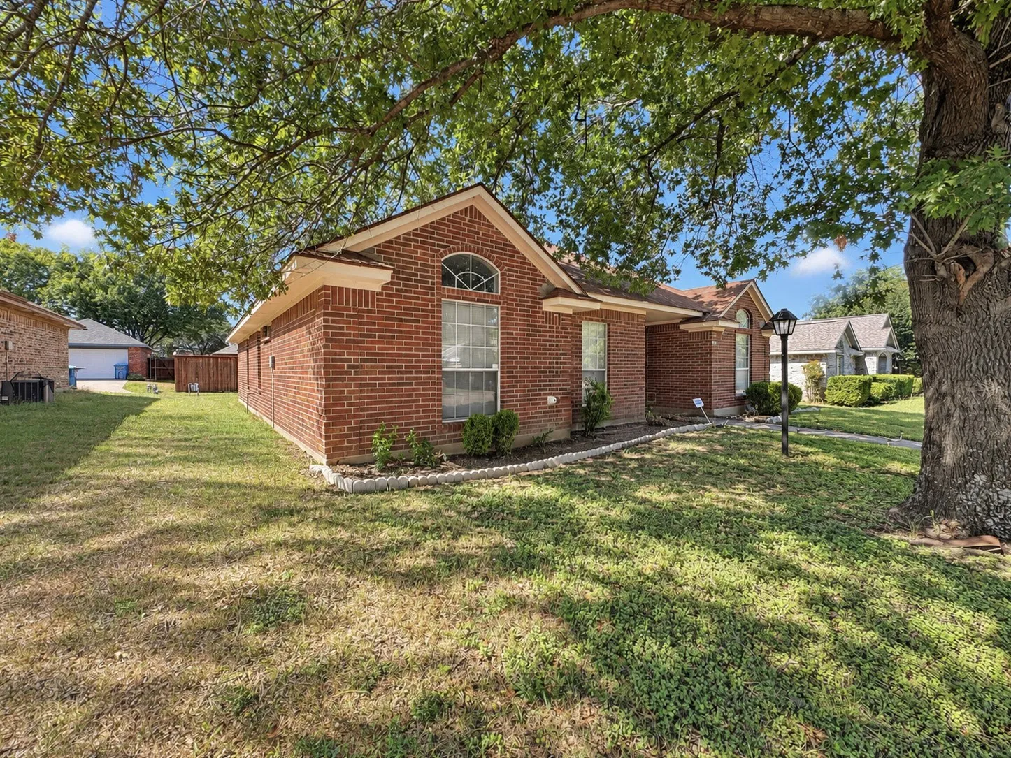 Red brick exterior with an arched window and covered front entry
