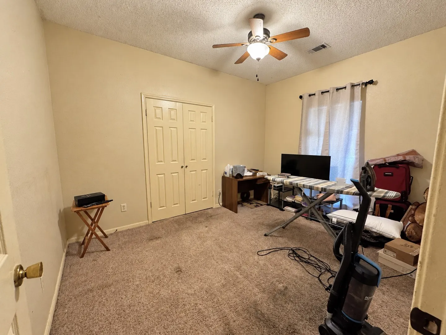 Recessed lighting with a ceiling fan, dual panel closet doors, and a window with curtain rods