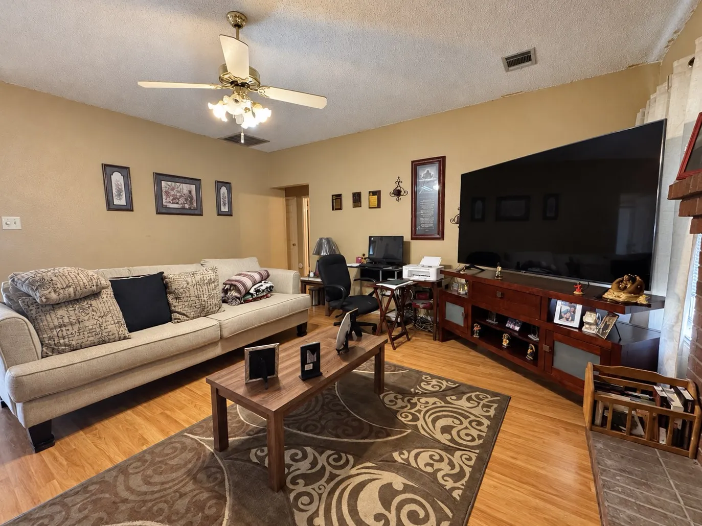 Hardwood-finish flooring, ceiling fan with integrated lighting, and a built-in entertainment console