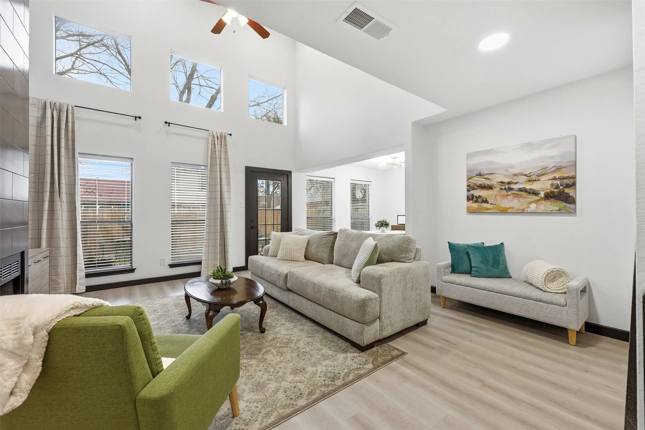 Vaulted ceiling with a ceiling fan, light wood-finish flooring, recessed lighting, and multiple windows