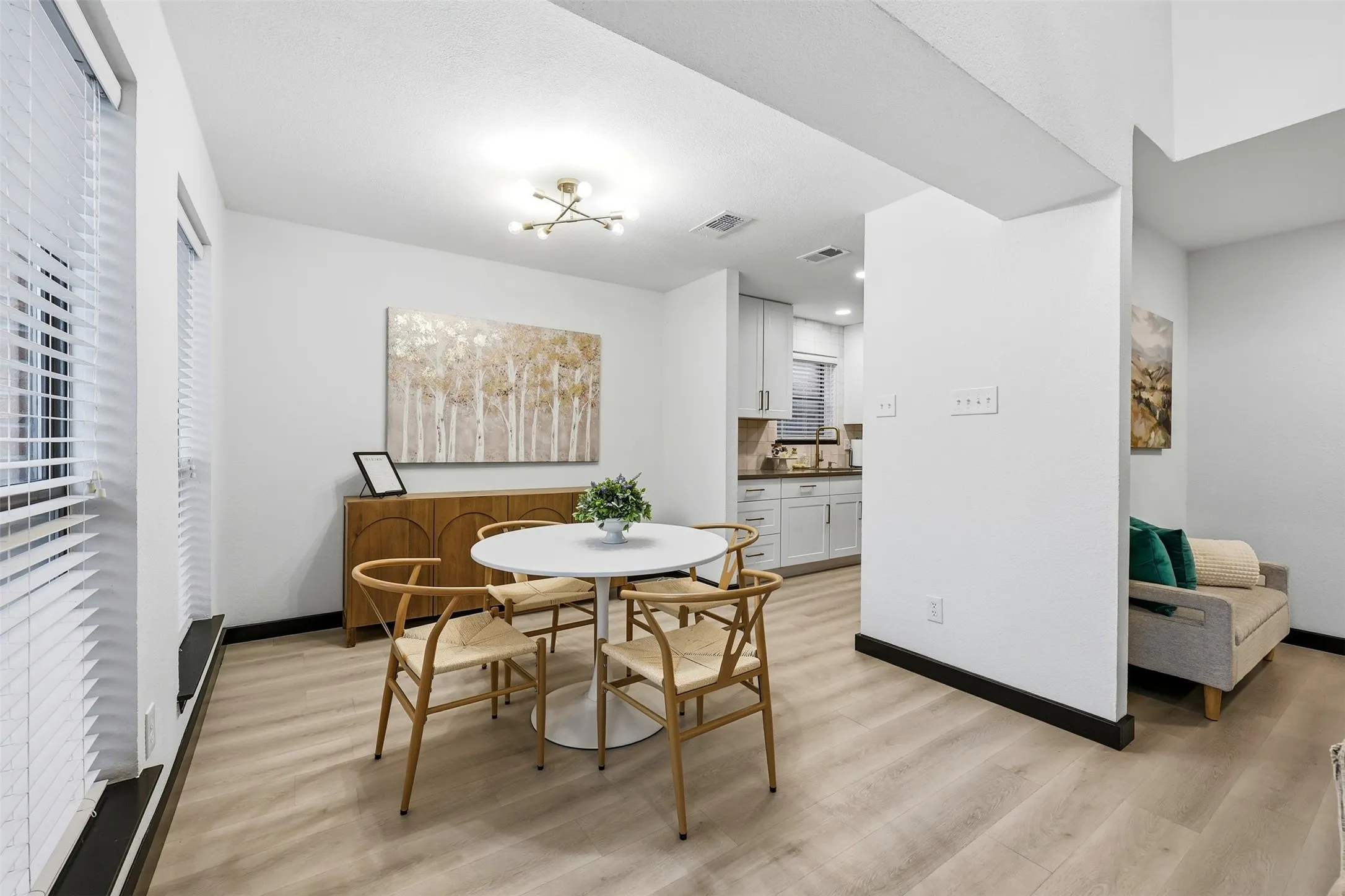 Recessed lighting, wood-finish flooring, white walls, white window blinds, and a contemporary ceiling fixture