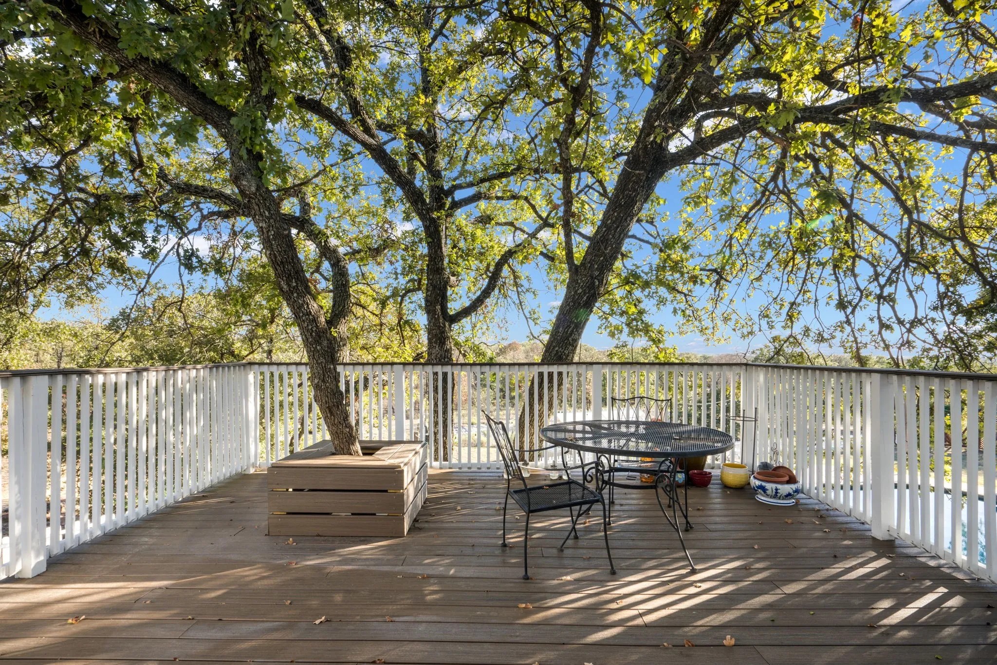 Expansive outdoor deck featuring wood-finish flooring and a white spindle railing