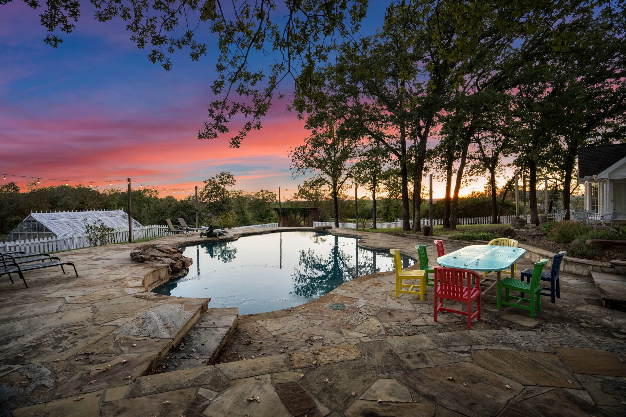 Freeform swimming pool with natural stone coping and a flagstone patio surround