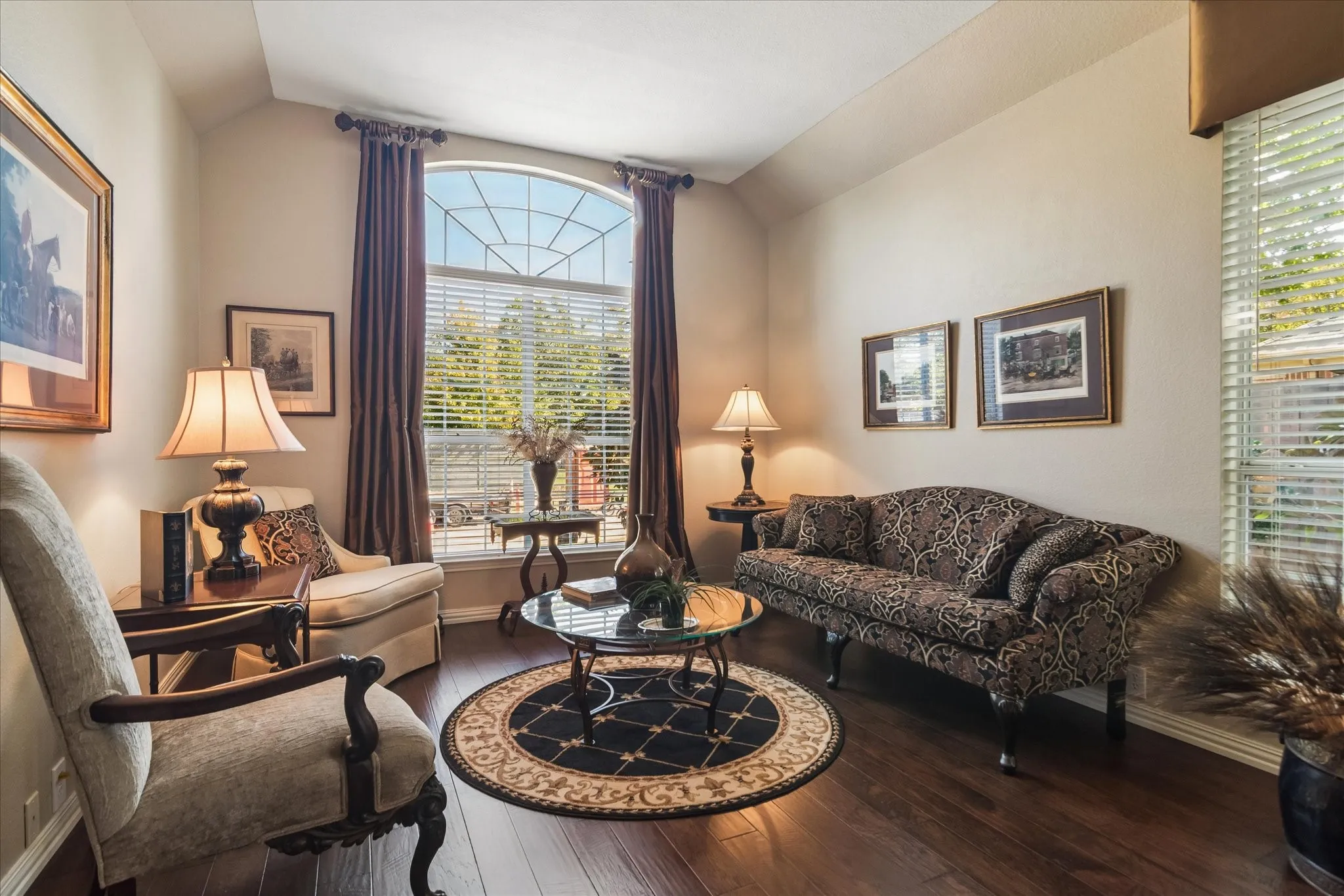 Arched window with gridded upper pane, wood-finish flooring, and light-toned wall paint