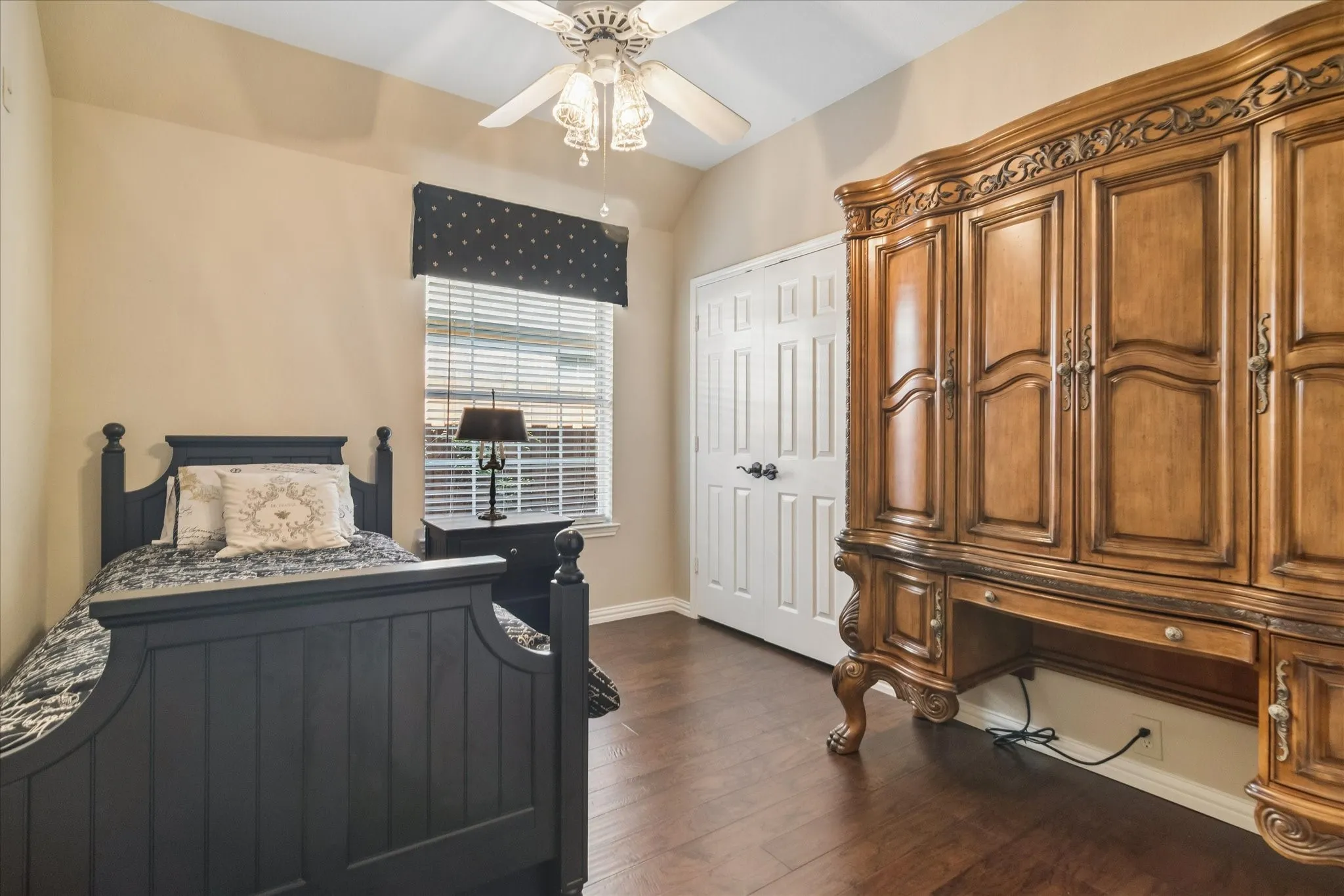 Wood-finish flooring, ceiling fan with integrated lighting, window with blinds and valance, and a paneled door