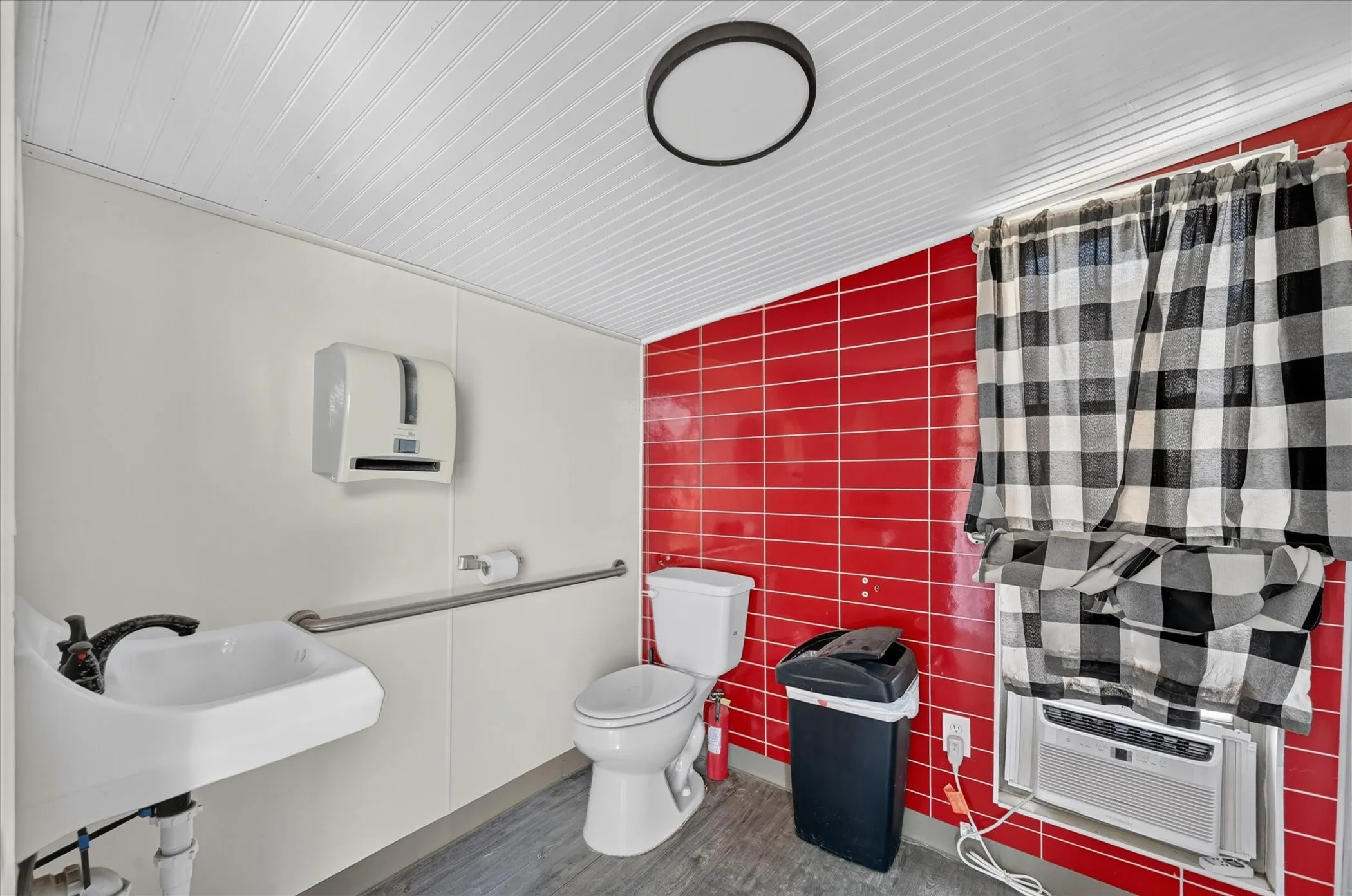 White wall panels, red tile wall, and wood-finish flooring